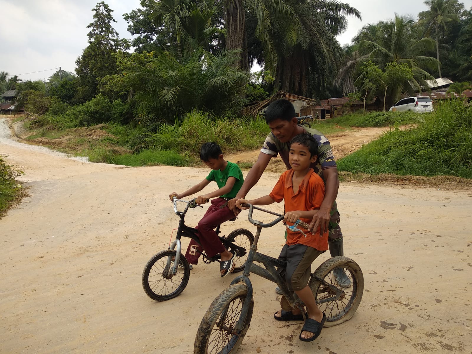 Di balik Tugas TMMD, Prajurit TNI Ini Hadirkan Senyum dan Kegembiraan Anak -anak dengan Bermain Sepeda Disela Istirahat