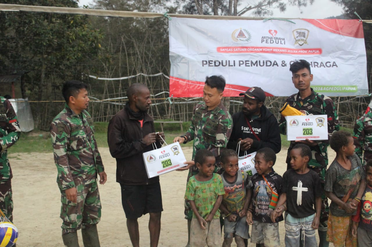 Satgas Yonif Mekanis 203/AK Membagikan Sarana Olahraga Kepada Pemuda Desa Tima