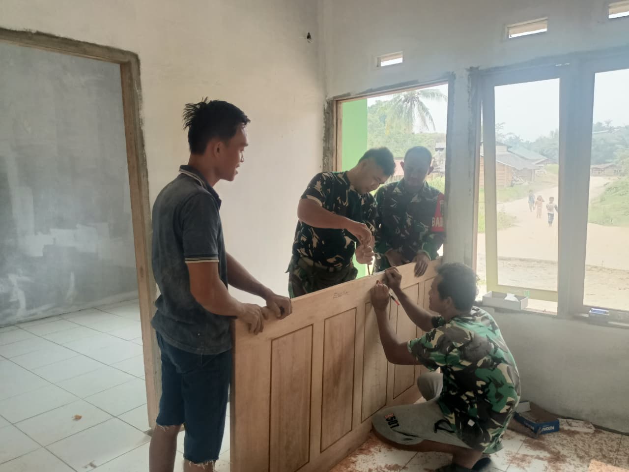Hangat Gotong Royong TMMD ke-127, TNI dan Warga Pasang Pintu Rumah Anismar