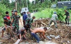 Prajurit Satgas Yonif 131/Brs dan Warga Bahu-membahu Bersihkan Material Sampah dan Lumpur